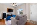 Cozy living room featuring a gray sofa, a large TV, and hardwood floors at 311 Tuggle Ct, Woodstock, GA 30188