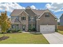 Charming two-story brick and stone home with a two-car garage, lush lawn and professional landscaping at 4259 Hansford Loop, Marietta, GA 30064