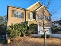 Two-story brick home with a large garage and mature trees at 5150 Amberland Sq, Atlanta, GA 30349