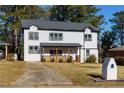 Two-story white house with gray roof, wooden porch, and landscaped yard at 2036 E Camellia Dr, Decatur, GA 30032