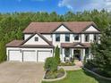 Stunning traditional home showcasing a three car garage, brick facade, and well-maintained landscaping at 334 Spotted Ridge Cir, Woodstock, GA 30188