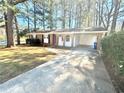 Charming brick home with a covered carport and a well-maintained front yard and a concrete driveway at 869 Meadow Rock Way, Stone Mountain, GA 30083