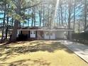 Cozy brick home featuring a covered carport and a spacious front yard, perfect for outdoor activities at 869 Meadow Rock Way, Stone Mountain, GA 30083