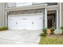 Two-car garage with white doors and stone accents at 7628 Squire Ct, Fairburn, GA 30213