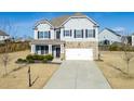 Two-story house with gray siding, stone accents, and a large driveway at 4675 Dandelion Way, Cumming, GA 30040