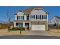 Two-story house with gray siding, stone accents, and a landscaped yard at 4675 Dandelion Way, Cumming, GA 30040