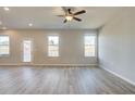 Spacious living room with wood-look floors and large windows at 17 Camellia Dr, Fairburn, GA 30213