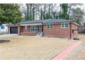 Attractive brick home with an attached garage, cozy front porch, and a walkway at 649 Ozburn Nw Rd, Atlanta, GA 30318
