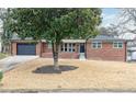 Charming brick home with a large tree in the front yard and a well-manicured lawn at 649 Ozburn Nw Rd, Atlanta, GA 30318
