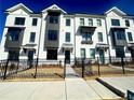 Modern townhome complex featuring white brick, black trim, and well-maintained landscaping for an appealing curb appeal at 518 Healy Dr # 68, Cumming, GA 30040