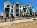 Modern townhome complex featuring white brick, black trim, and well-maintained landscaping for an appealing curb appeal at 518 Healy Dr # 68, Cumming, GA 30040