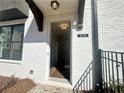 Elegant entryway with white brick facade, black trim, and visible house number creating a welcoming entrance at 518 Healy Dr # 68, Cumming, GA 30040