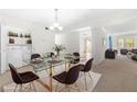 Modern dining area with glass table, chairs, and built-in shelving at 6851 Roswell Rd # I29, Atlanta, GA 30328
