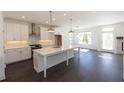 Modern white kitchen with island, stainless steel appliances, and dark hardwood floors at 712 Dodd Ln # 154, Buford, GA 30518