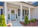 Inviting front porch with light blue door and charming landscaping at 754 Somersby Dr, Dallas, GA 30157