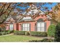 Red brick house with gray roof, shutters, and autumn leaves at 6204 Woodlore Nw Dr, Acworth, GA 30101