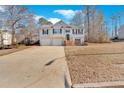 Tan house with a two-car garage and a view of the front yard at 66 Trevor Way, Temple, GA 30179