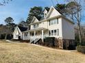 Two-story house with a wraparound porch and landscaping at 4817 Carlene Sw Way, Lilburn, GA 30047