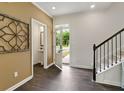 Spacious foyer with dark hardwood floors, powder room, and staircase at 8235 Walnut Hall Dr, Fairburn, GA 30213