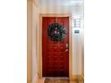 Red front door adorned with a lush green wreath, welcoming residents into their home at 10 Perimeter Summit Ne Blvd # 4315, Brookhaven, GA 30319