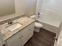 White vanity with granite countertop, single sink, and a bathtub at 444 Kara Ln, Mcdonough, GA 30253