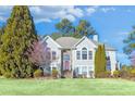 Two-story house with gray siding, red door, and landscaping at 6733 Holiday Pt, Buford, GA 30518