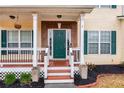 Green front door with a brick entryway and a wooden porch at 9020 Amberly Way, Cumming, GA 30028