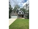 Charming two-story home featuring stone accents, a well-manicured lawn, and an attached two-car garage at 321 Evie Ln, Canton, GA 30115