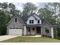 Attractive two-story home with a stone and siding exterior and a well-maintained lawn and charming front door at 321 Evie Ln, Canton, GA 30115