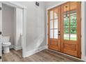 Bright foyer featuring hardwood floors, a stylish double door, and a conveniently located powder room at 321 Evie Ln, Canton, GA 30115