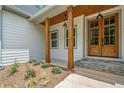Inviting covered porch with stylish wood columns and a charming wood front door at 321 Evie Ln, Canton, GA 30115