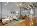 Spacious living room featuring hardwood floors, neutral decor, and a view into the modern kitchen area at 1058 Piedmont Ne Ave # 302, Atlanta, GA 30309