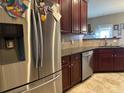 Stainless steel refrigerator in a kitchen with dark wood cabinets and granite countertops at 709 Chapman St, Jonesboro, GA 30238