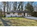 White brick ranch house with a nicely landscaped yard and a long driveway at 1120 Starline Se Dr, Smyrna, GA 30080