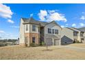 Two-story house with brick and siding accents, two-car garage, and a landscaped yard at 12 Enclave Blvd, Covington, GA 30014