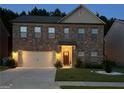 Two-story brick home with a large front yard, illuminated at night at 1797 Weatherbrook Cir, Lawrenceville, GA 30043