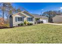 House with a well-maintained lawn, attached garage, and neutral color scheme at 775 Holcombe Woods Ct, Auburn, GA 30011