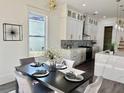 Elegant dining area adjacent to the kitchen with a modern table and decorative lighting fixture at 503 Glendale Rd, Scottdale, GA 30079