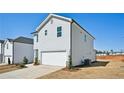 Two story home featuring a two car garage, light gray siding and a concrete driveway at 2032 Avalon Rdg, Conyers, GA 30013