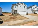 Two story home featuring a two car garage, light gray siding and a concrete driveway at 2032 Avalon Rdg, Conyers, GA 30013