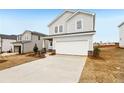 Charming two-story home with light gray siding, a two-car garage, and a long concrete driveway at 2036 Avalon Rdg, Conyers, GA 30013