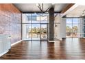 Open living area with hardwood floors, brick accent wall, and large windows at 3400 Malone Dr # 320, Atlanta, GA 30341