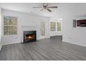 Living room with fireplace, gray vinyl flooring, and access to the back patio at 6876 Wildboar Dr, Fairburn, GA 30213