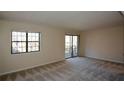 Living room featuring carpeted floors, large windows, and sliding glass door to balcony at 475 Mount Vernon Ne Hwy # C-220, Sandy Springs, GA 30338