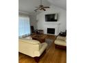 Spacious living room featuring hardwood floors, a fireplace, and large TV at 5958 King Way Walk, Lithonia, GA 30058
