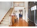 Inviting home foyer with hardwood floors, staircase, and entry to other rooms at 3472 Honeycomb Se Dr, Conyers, GA 30094