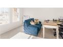 Home office with a blue couch and a wooden desk by the window at 7767 Richmond Trl, Fairburn, GA 30213