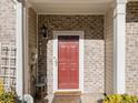 Red front door entry to brick townhouse at 566 Maggie Ln, Jonesboro, GA 30238