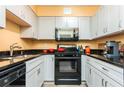 A compact kitchen with black countertops, stainless steel appliances, and white cabinetry at 2479 Peachtree Ne Rd # 202, Atlanta, GA 30305