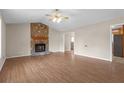 Living room with stone fireplace and laminate flooring at 1308 Crumbley Rd, Mcdonough, GA 30252
